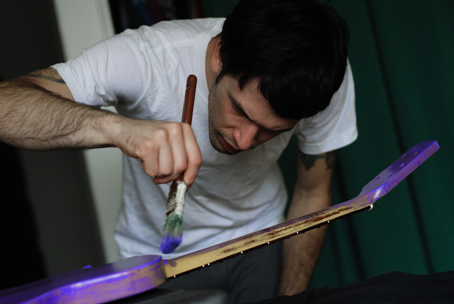 Joel Nass of The Violet Lights paints a guitar purple
